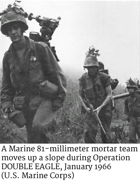 A Marine 81-millimeter mortar team moves up a slope during Operation DOUBLE EAGLE, January 1966. (U.S. Marine Corps)